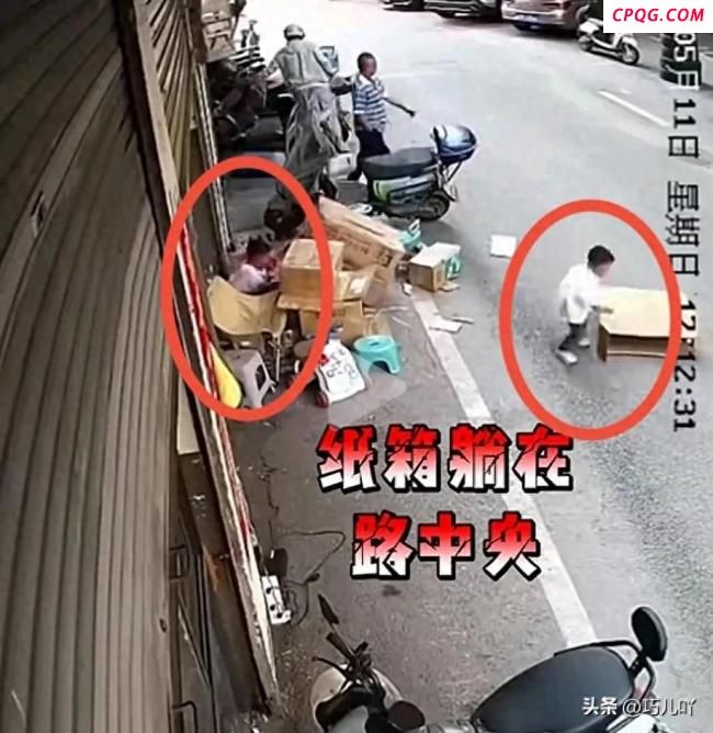 男孩钻进路边纸箱内险被车辆轧上