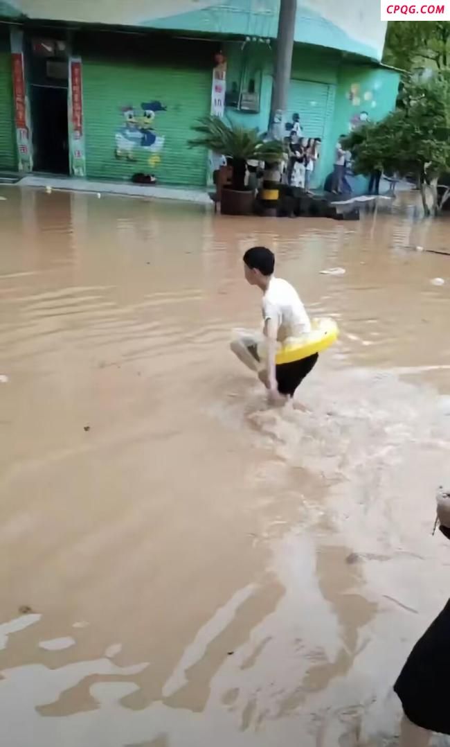 考生因暴雨带救生圈蹚水赶考