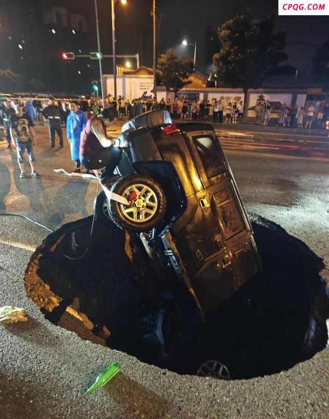 路面塌陷小车栽入坑中 路人破窗救人