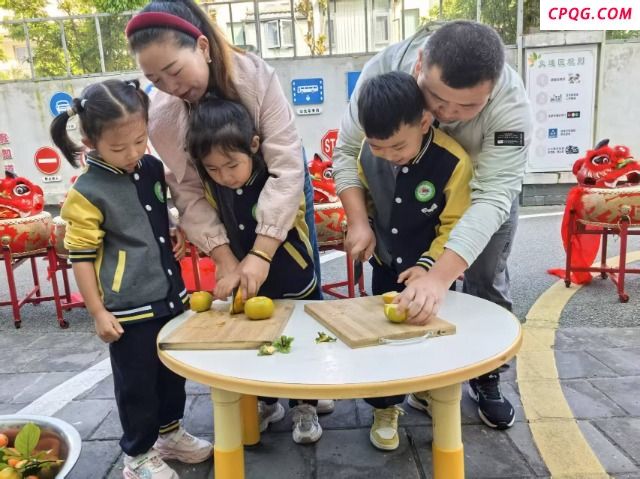 姚安县幼儿园小朋友和家长一起切柿子。吴艳芹摄.jpg